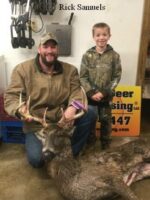 Man and boy holding killed buck